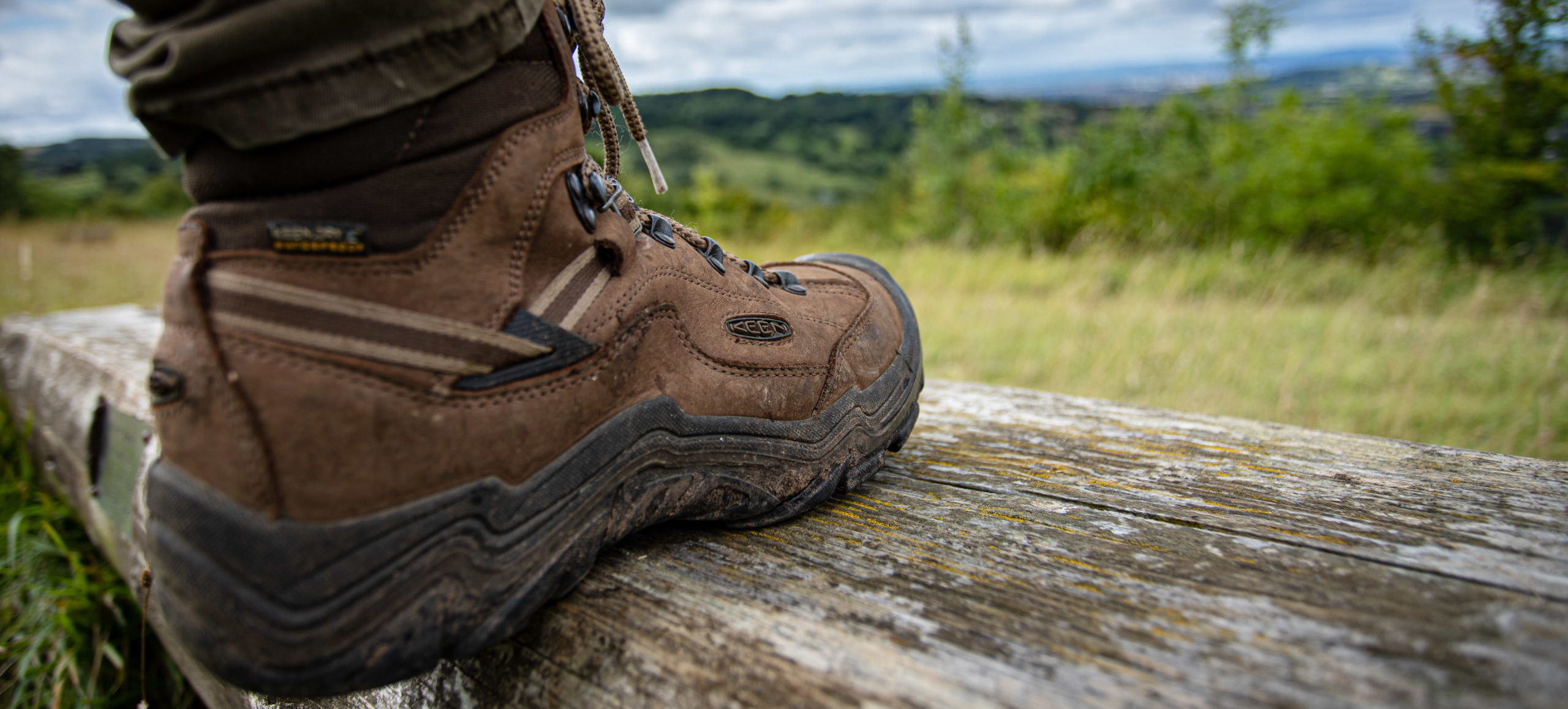 A booted foot stepping on a log