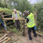 2 wardens in yellow high viz jackets installing a wooden pedestrian gate