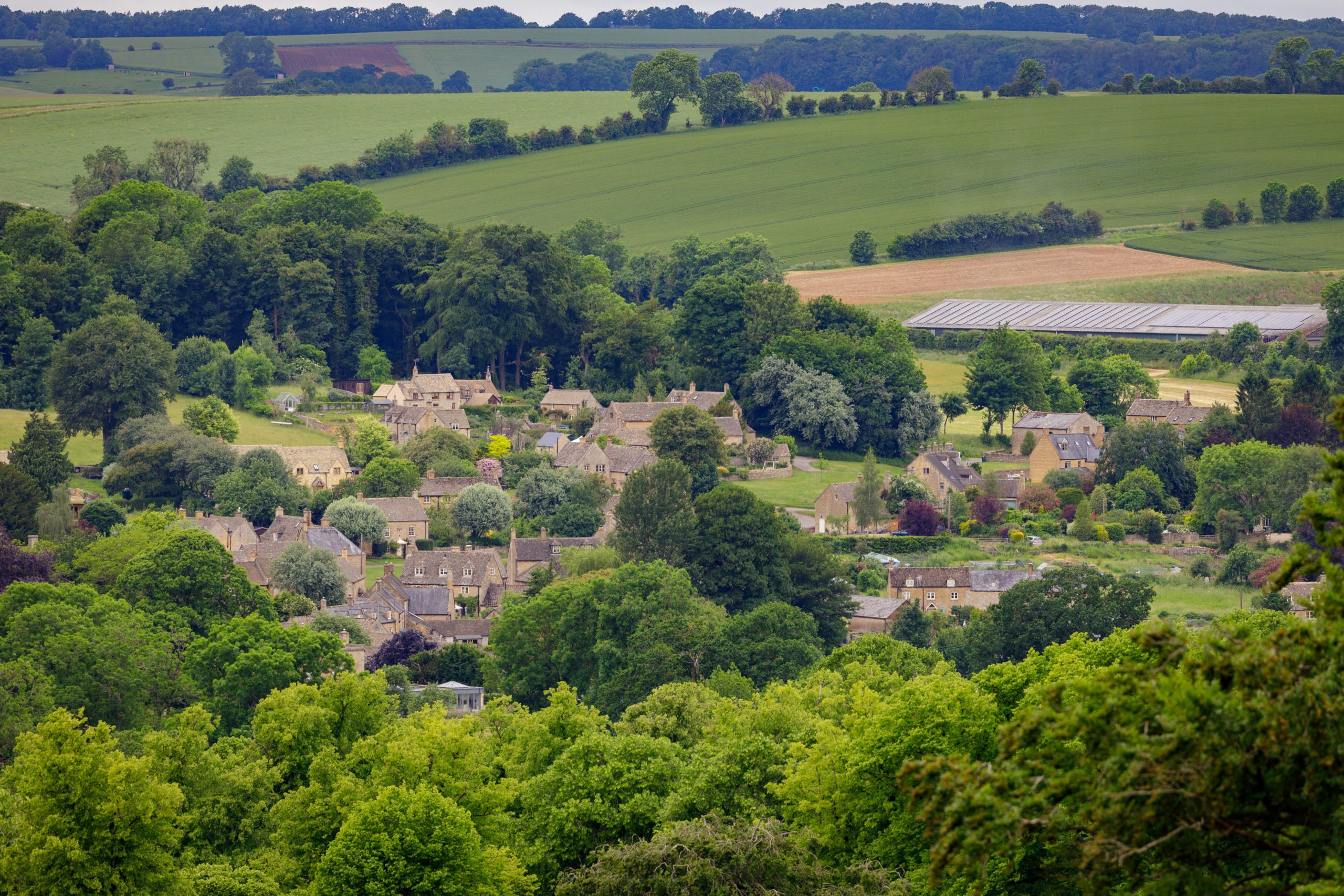 View of the Cotswolds countryside, with the village of Guiting Power nestled in the distance.