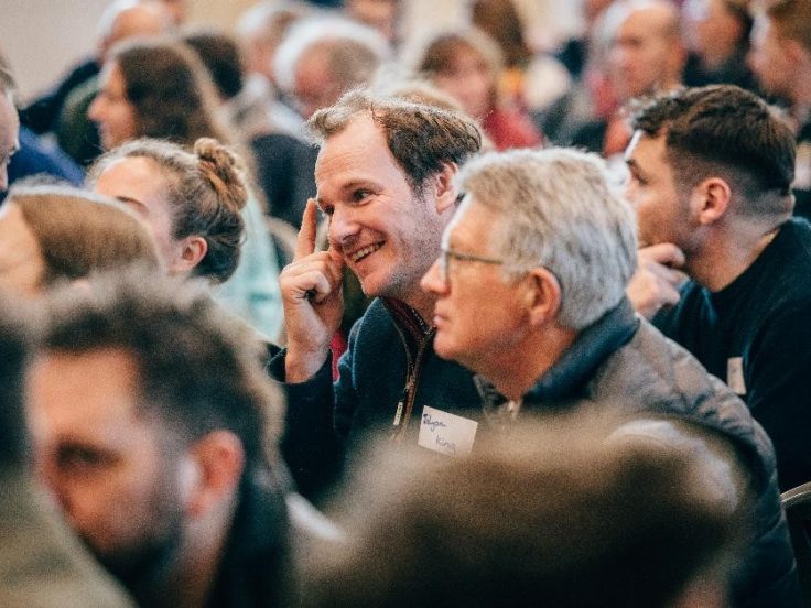 Image shows a number of people seated at a conference. Image credit: Tea Smart.