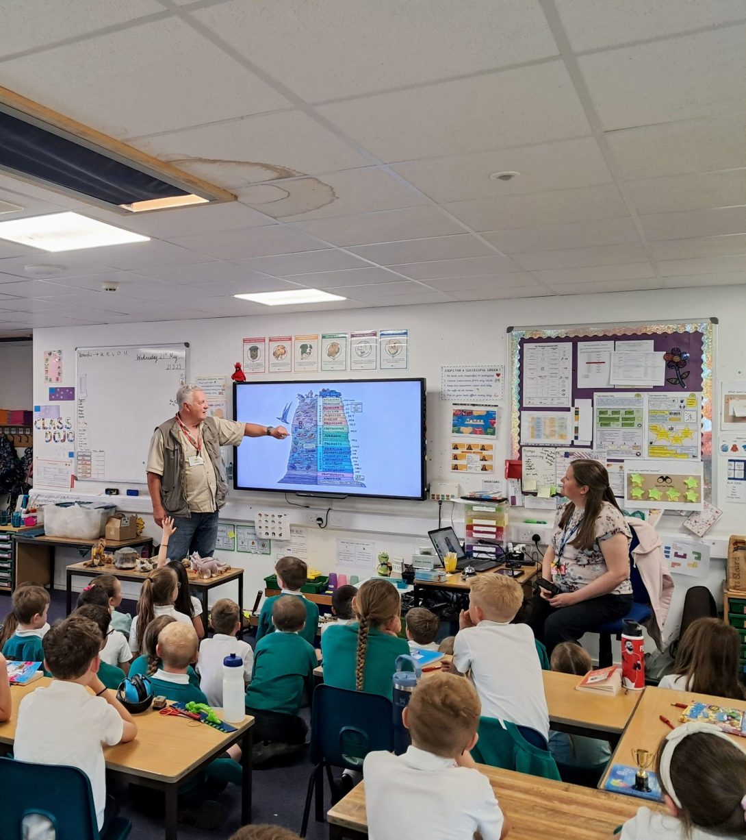 Image shows Gareth Beamish leading a session on fossils in front of a class of primary school pupils.